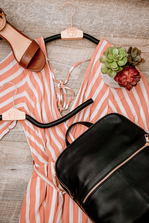 Pink shirt with bendable hanger and black bag